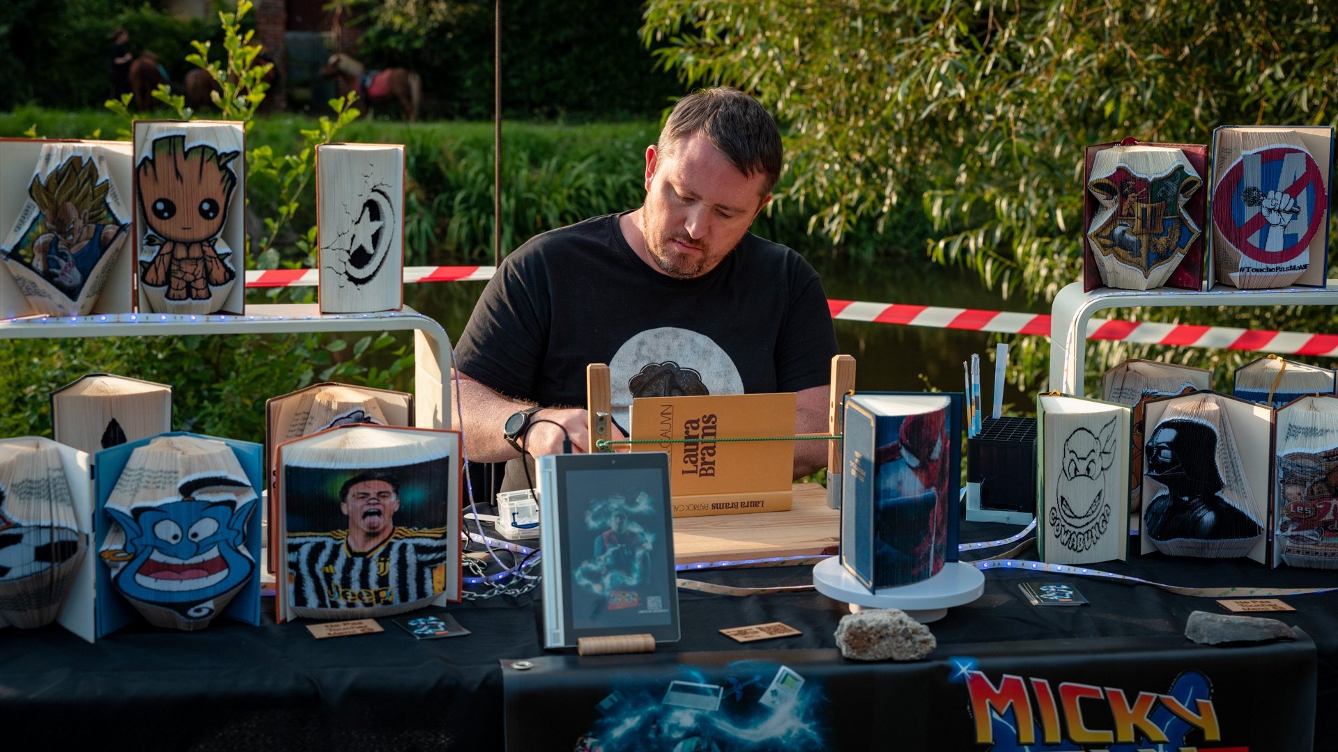 Micky McFly en création sur son stand, entouré de ses œuvres